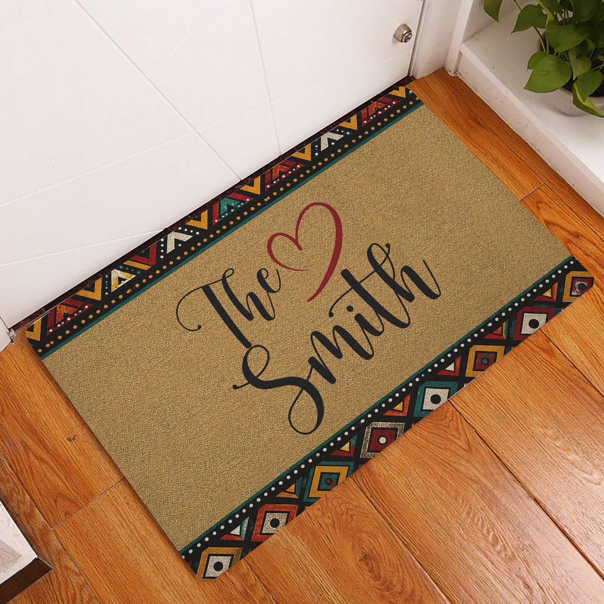 African-inspired entryway doormat displayed on a wood floor beside a white door
