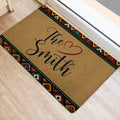 Colorful geometric African-inspired rug placed at an indoor doorway on a light wood floor