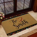 African-inspired patterned doormat styled at a glass entrance with flowers and indoor flooring