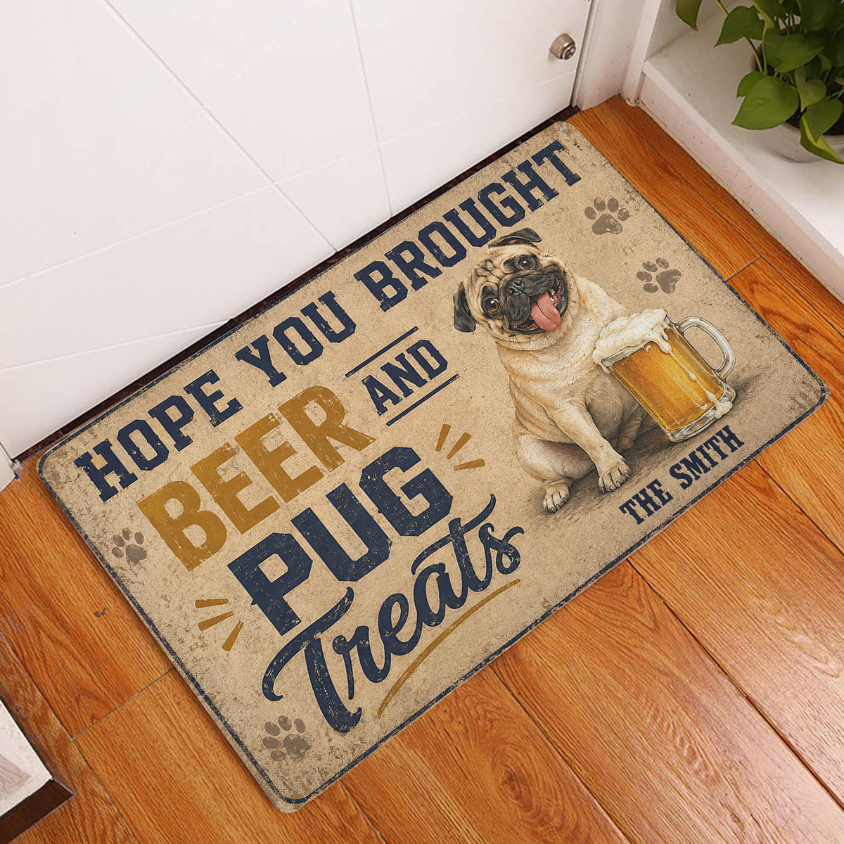 Pug beer-themed doormat displayed at an indoor doorway on a warm wood floor