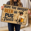 Person holding a playful pug and beer doormat in a home interior