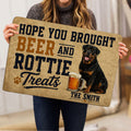 Person holding a Rottweiler doormat featuring vintage lettering, paw print, and beer mug artwork