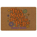 Hippie peace-inspired doormat with colorful flowers, stars, retro lettering, and a family welcome design