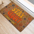 Retro peace sign and daisy doormat placed beside a light-colored front door