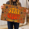 Hippie-style floral peace sign doormat held indoors, showing its bright retro artwork