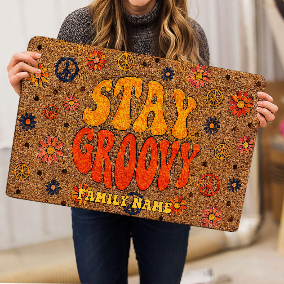 Hippie-style floral peace sign doormat held indoors, showing its bright retro artwork