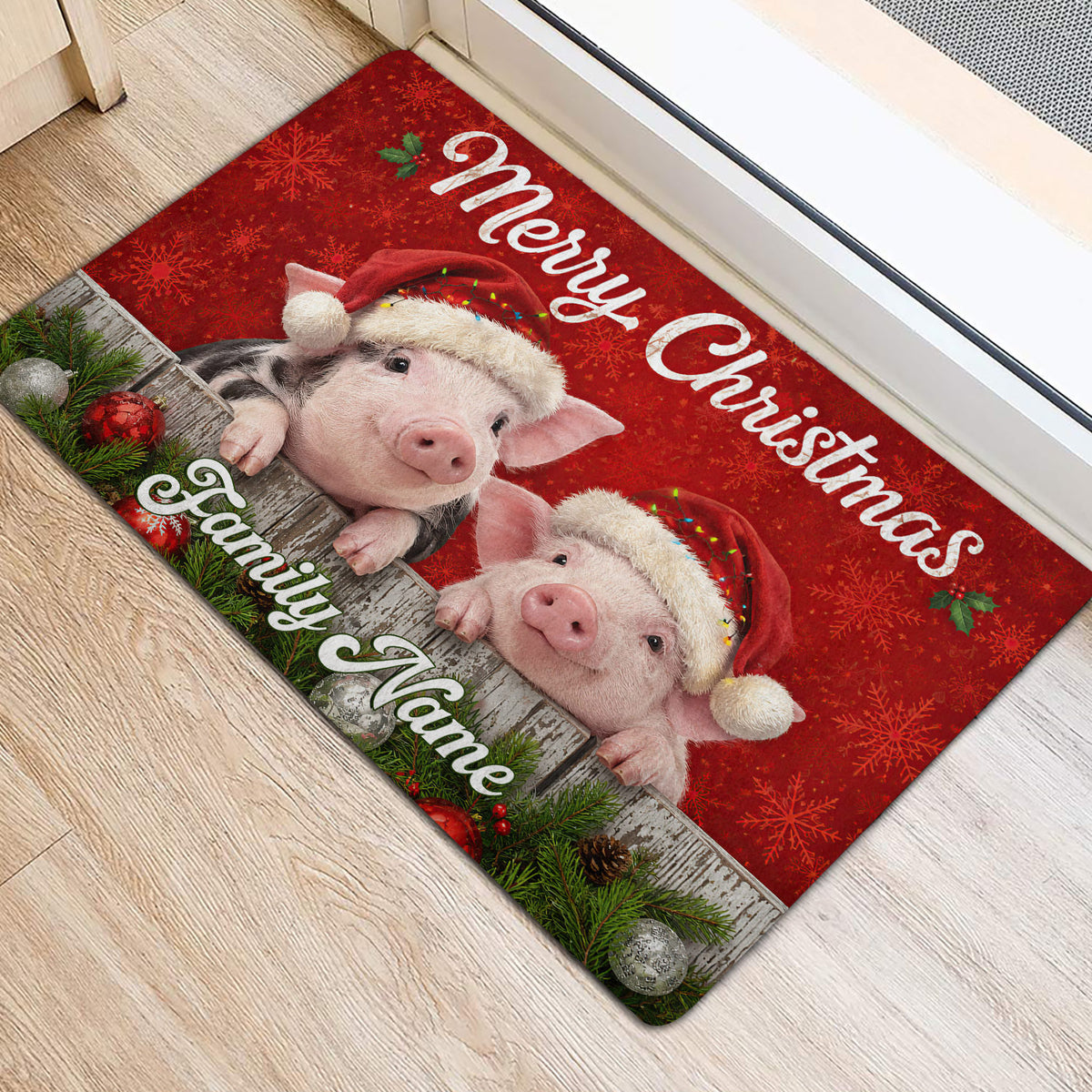 Festive pig doormat positioned at an indoor doorway with two Santa hat pigs, greenery, and ornaments