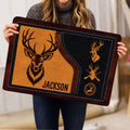 Person holding a rustic hunting doormat featuring deer, antlers and outdoor-inspired artwork