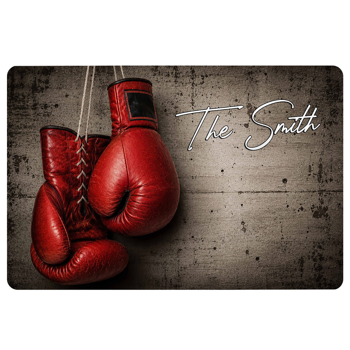 Red boxing gloves on a dark concrete-style doormat with white script lettering
