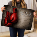 Boxing glove doormat held indoors, showing the full dark artwork and red glove design