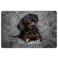 Black and tan dachshund portrait on a cracked gray stone-style doormat with decorative script lettering