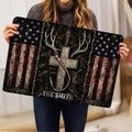 Hunting doormat shown in an entryway with deer antlers, bow, woodland artwork, and distressed flag styling