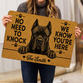 Cane Corso doormat held indoors, featuring a large black illustrated dog portrait and paw-print accents