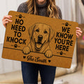 Person holding a Labrador Retriever doormat featuring a friendly dog portrait, paw prints and tan artwork
