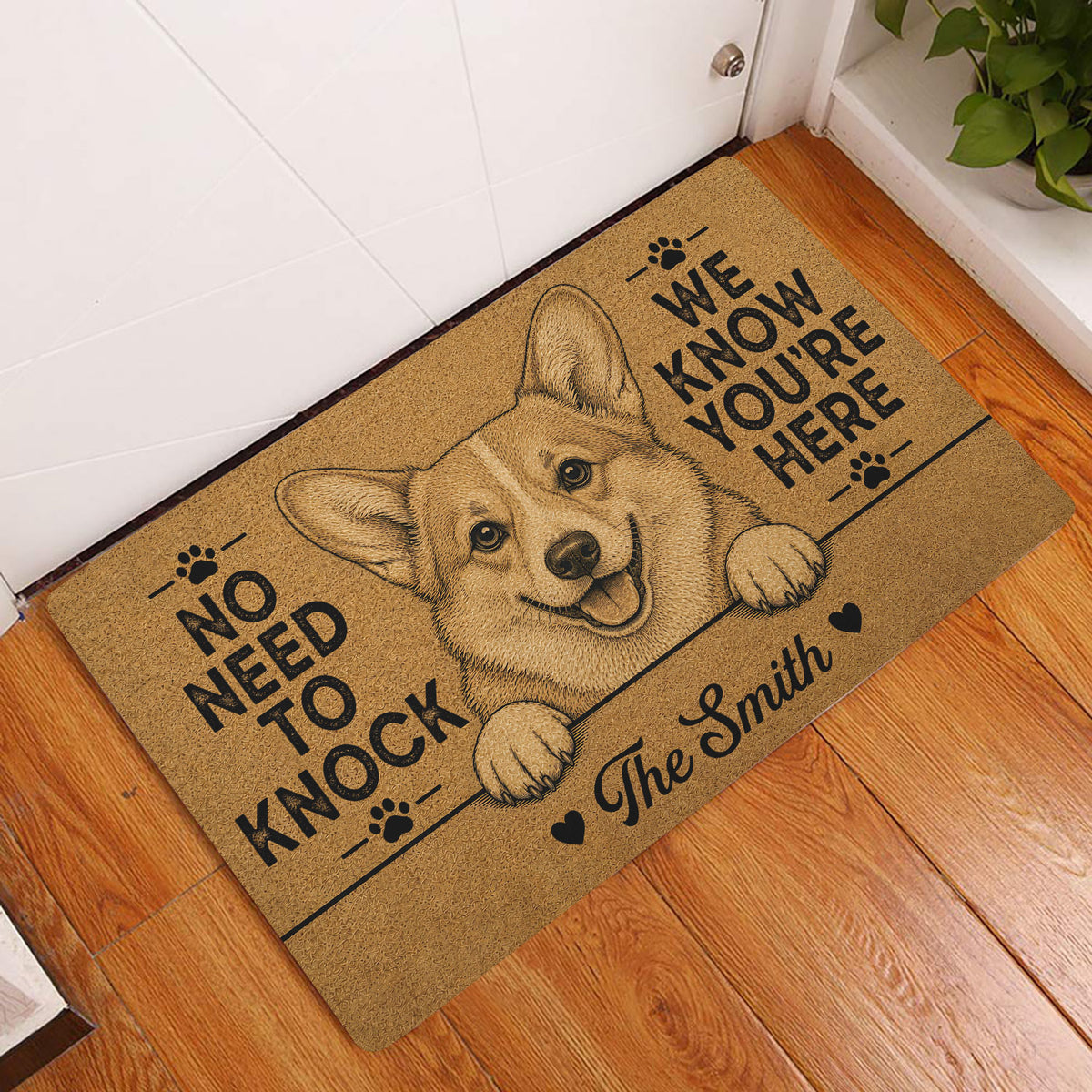 Golden corgi entryway rug displayed beside a white door on a warm wood floor
