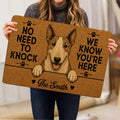 Person holding a sepia Bull Terrier doormat featuring paw prints, bold lettering and heart accents