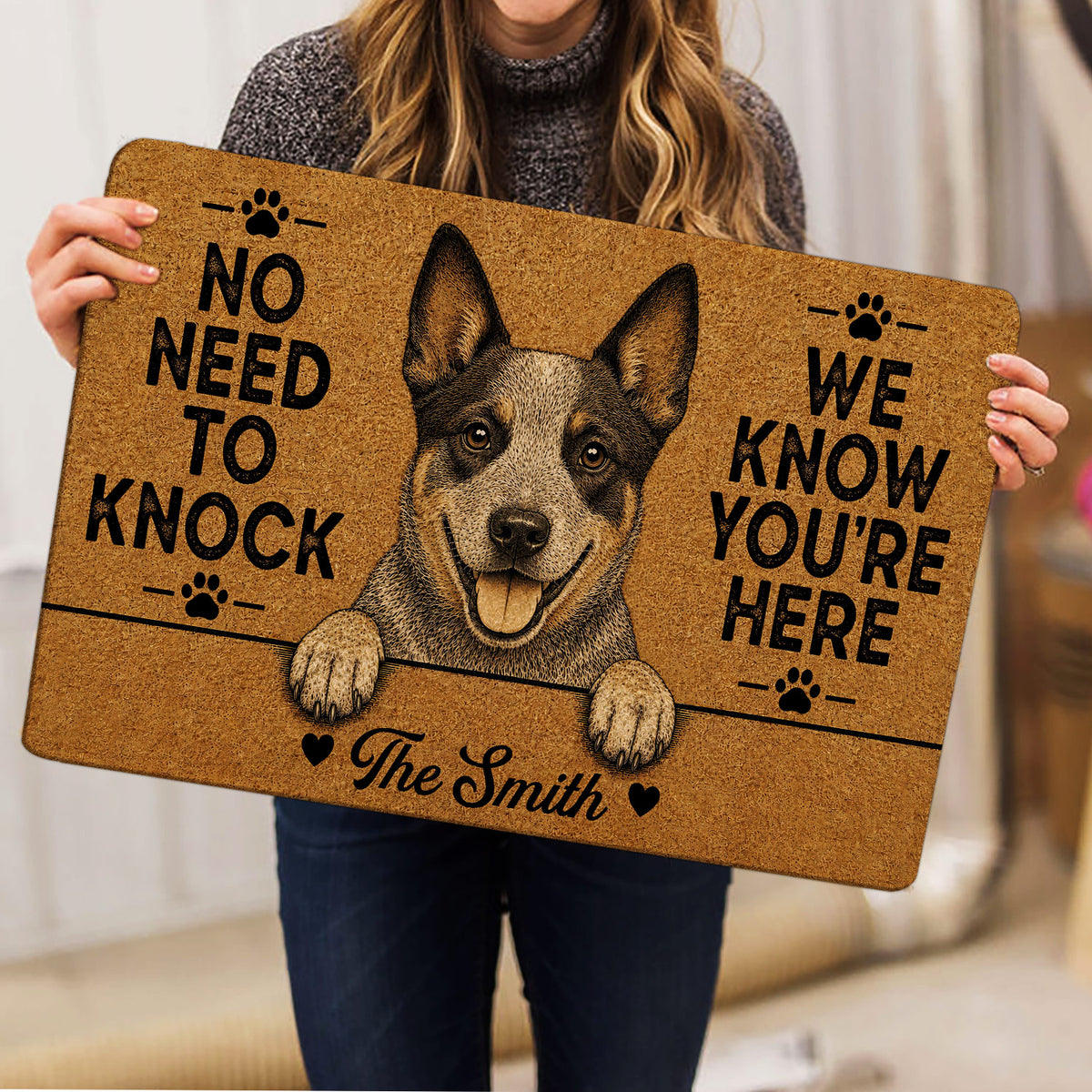 Person holding an Australian Cattle Dog doormat featuring a detailed portrait, paw prints and bold black lettering