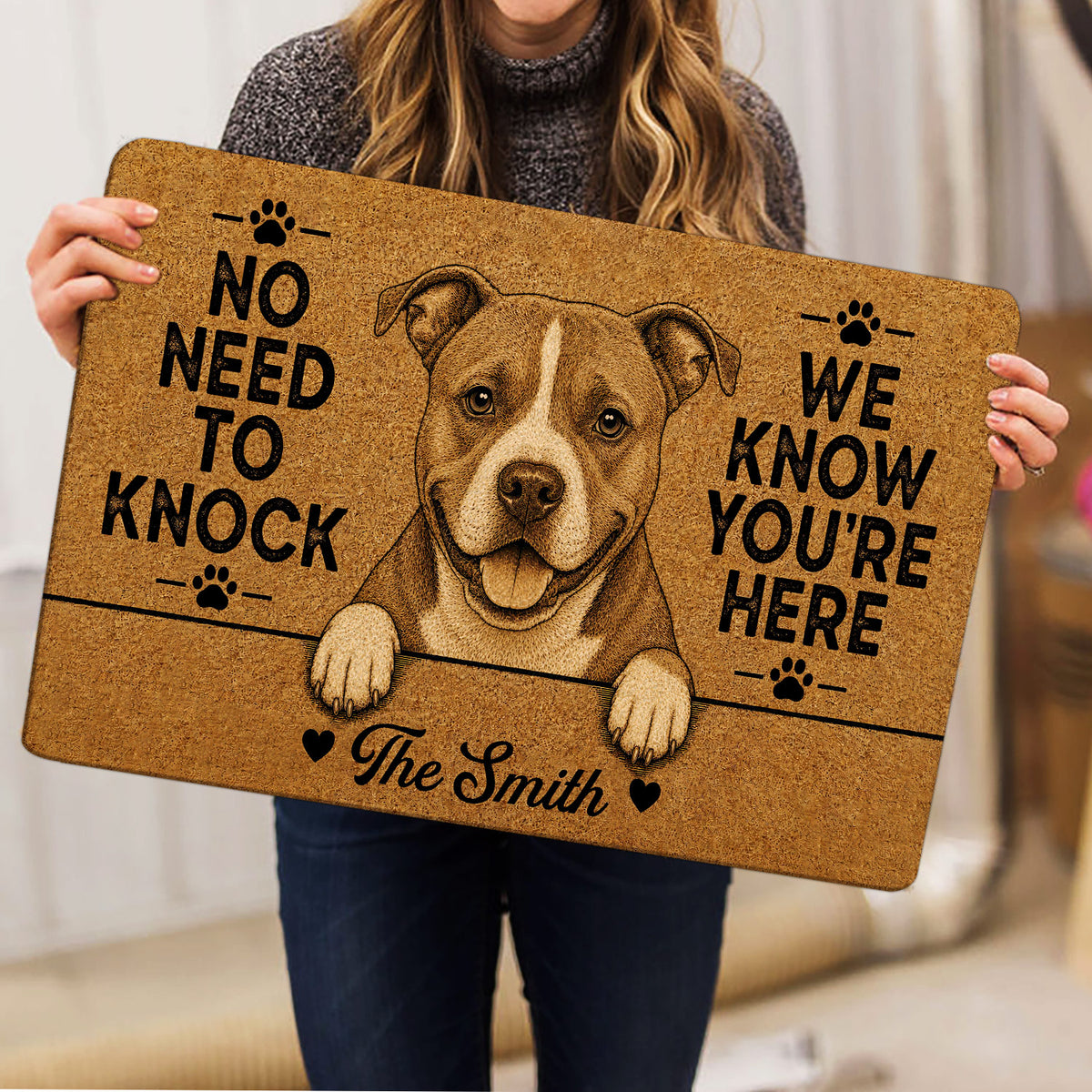 Person holding an American Staffordshire doormat featuring a detailed dog portrait and playful paw-print design