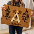 Person holding a Jack Russell terrier doormat with paw prints and playful entryway artwork