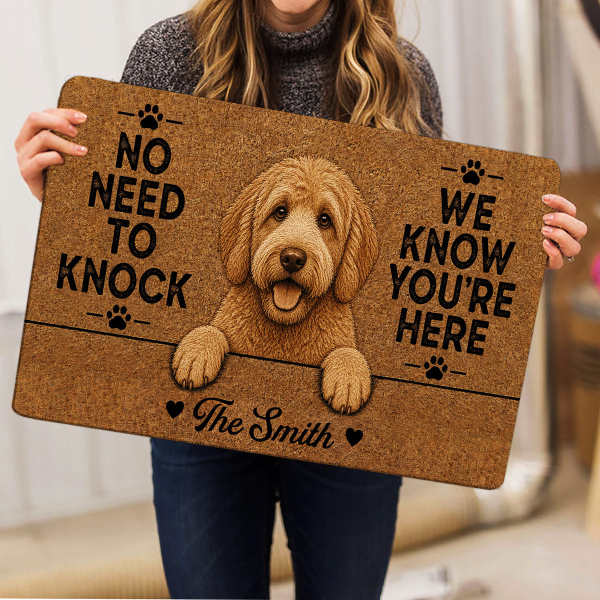 Person holding a Labradoodle doormat featuring a cheerful dog portrait and paw print accents