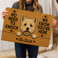 Person holding a Westie doormat featuring a terrier portrait, paw prints, and a welcoming entryway message