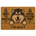 Alaskan Malamute doormat with paw prints, warm brown artwork, and a playful welcome message