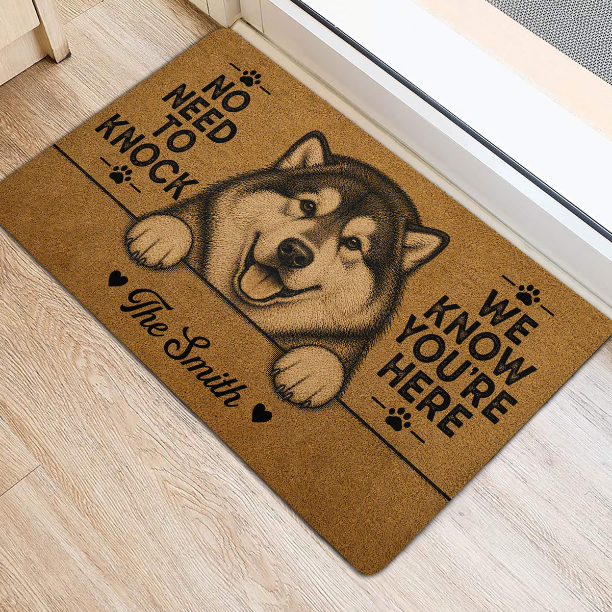 Alaskan Malamute front door mat shown on light flooring with paw print artwork and lettering