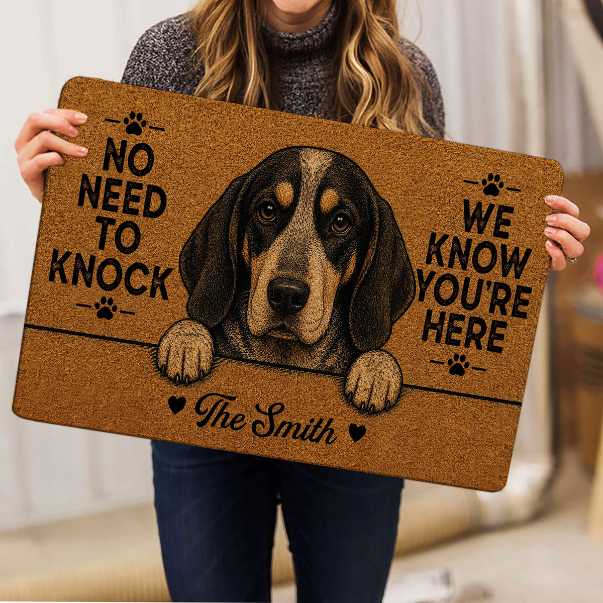 Person holding a Bluetick Coonhound doormat featuring a detailed dog portrait and paw-print artwork