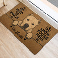 White dog portrait doormat displayed beside a doorway, featuring paw prints and bold black lettering