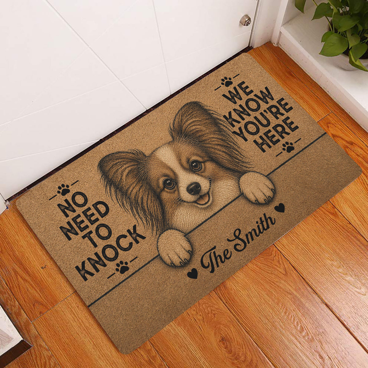 Papillon dog entryway rug displayed beside a white door on a warm wood floor