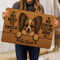 Person holding a Papillon dog doormat featuring a detailed portrait and playful paw print design