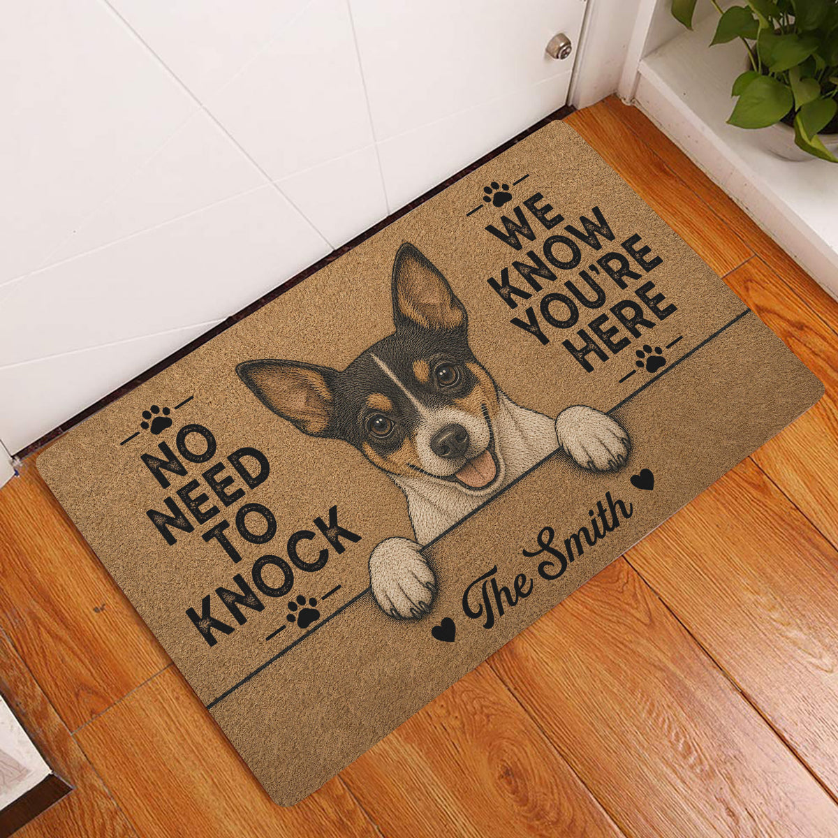 Rat Terrier doormat styled at an indoor entryway beside a white door and wood flooring