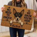 Person holding a tan Rat Terrier doormat with a playful dog portrait and paw print accents