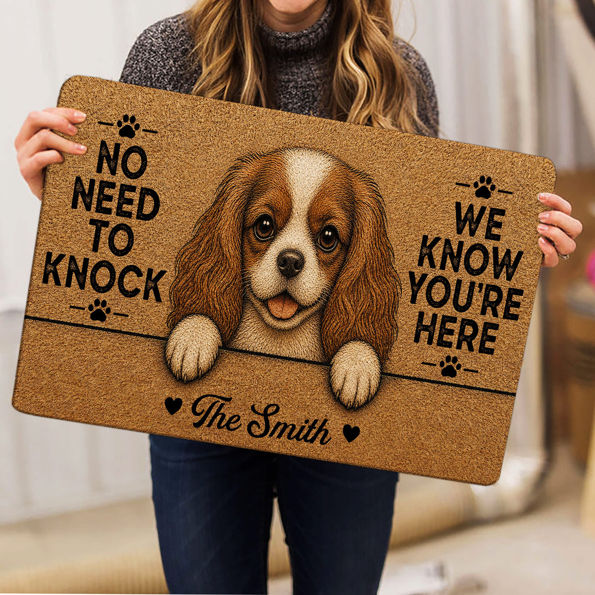 Cavalier King Charles Spaniel doormat held indoors, featuring a realistic dog portrait and welcome artwork