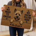 Person holding a Cairn Terrier doormat featuring a shaggy dog portrait and bold black lettering