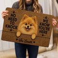 Person holding a Pomeranian doormat displaying a fluffy tan dog, paw prints, hearts, and welcoming lettering