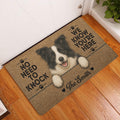Border Collie entryway rug displayed beside a white door on a warm wood floor