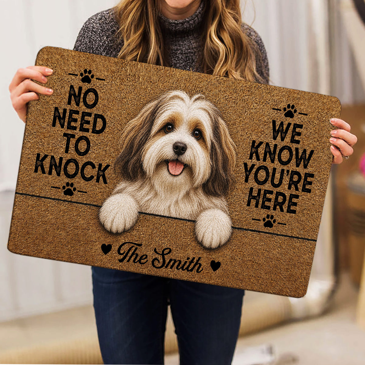 Person holding a Havanese dog doormat featuring a warm brown portrait and paw print details