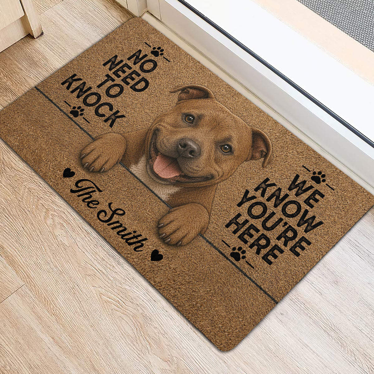 Staffordshire Bull Terrier entryway rug displayed beside a doorway with paw prints and humorous lettering