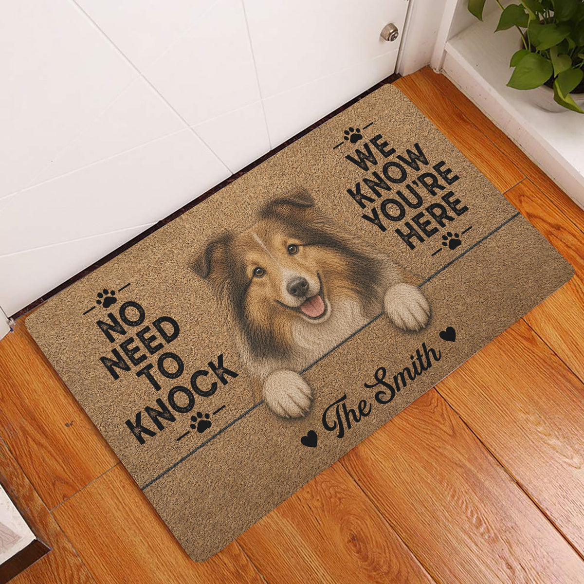 Sheltie doormat displayed by a white door on a wood floor, featuring a friendly dog portrait and paw prints