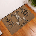 Greyhound entryway rug displayed beside a white door on warm wood flooring
