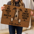 Person holding a greyhound doormat with a realistic dog portrait and bold black lettering