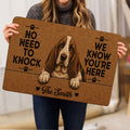 Person holding a Basset Hound doormat featuring a realistic dog portrait and playful black lettering