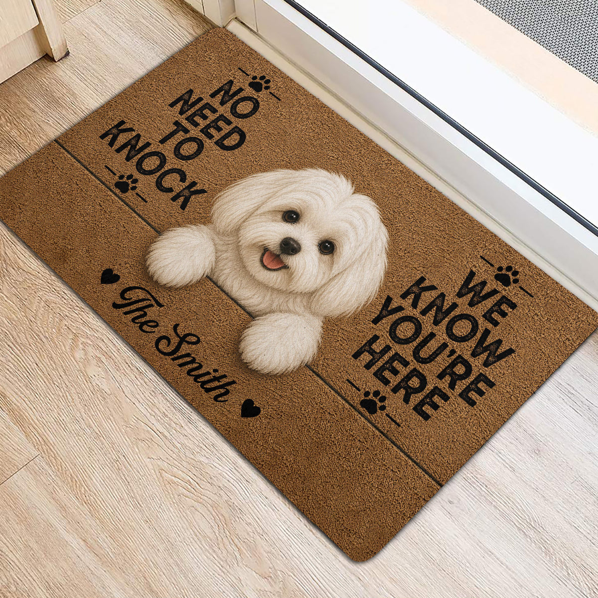 Maltese welcome mat shown beside a bright doorway with a white dog illustration and paw print accents