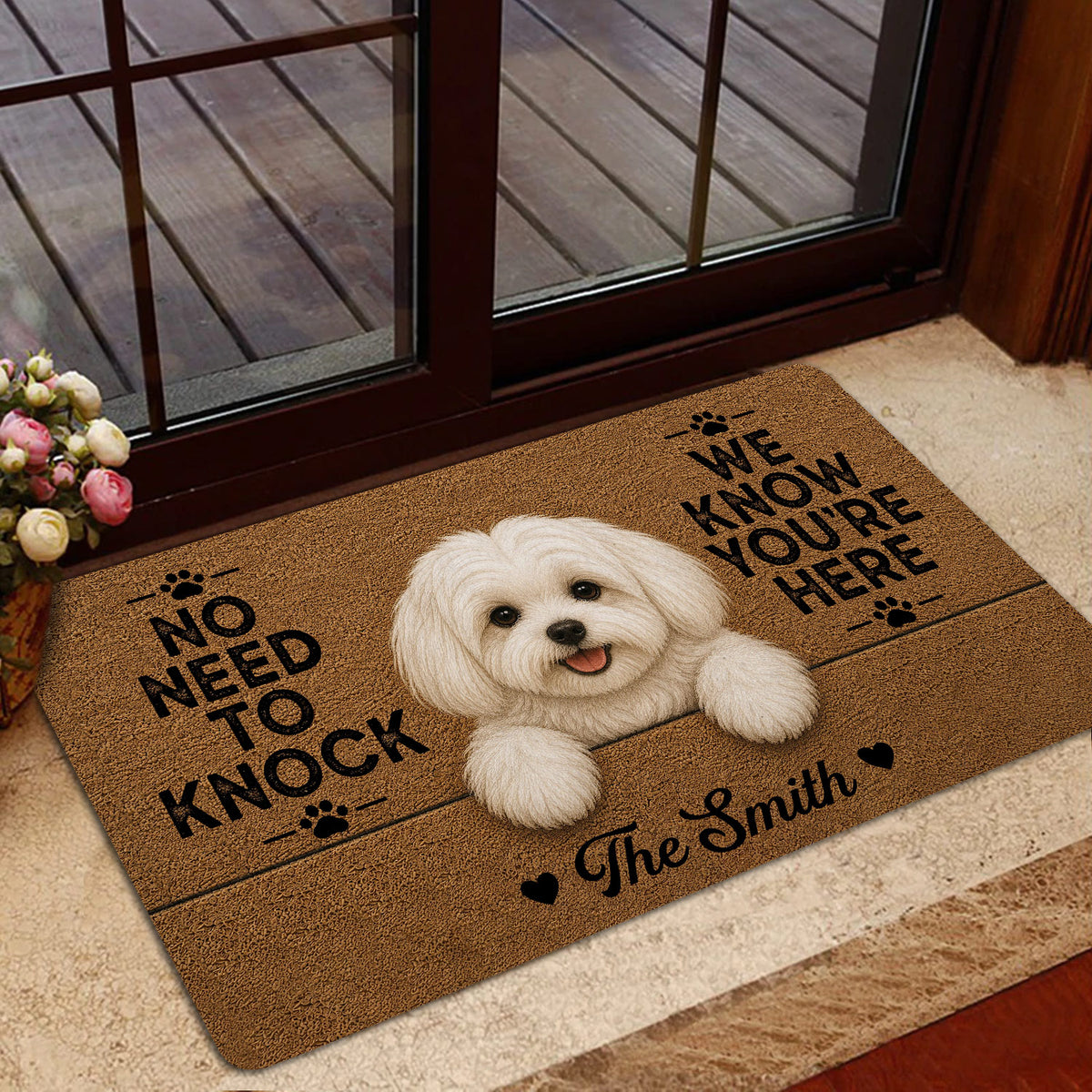 Maltese doormat styled in a home entrance with a white dog design, paw prints, and dark decorative lettering