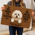 Person holding a Maltese dog doormat featuring a white dog portrait, paw prints, hearts, and warm brown artwork