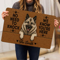 Norwegian Elkhound doormat held indoors, showing the realistic dog artwork and welcoming paw-print design