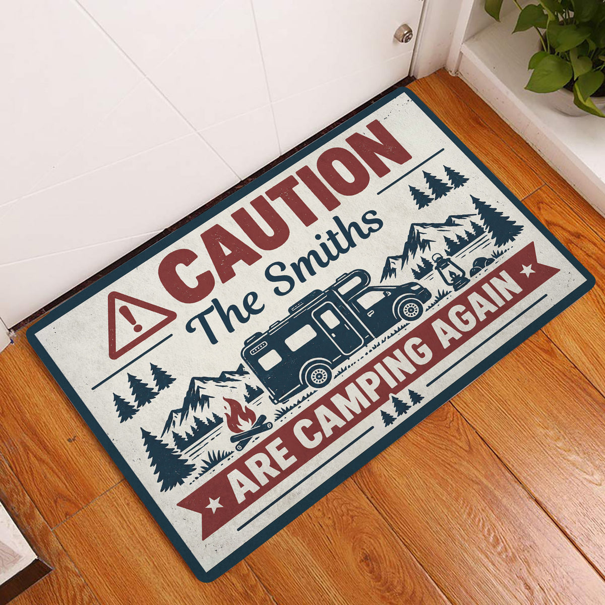 Camping doormat displayed at an indoor doorway with RV, mountain, pine tree and campfire artwork
