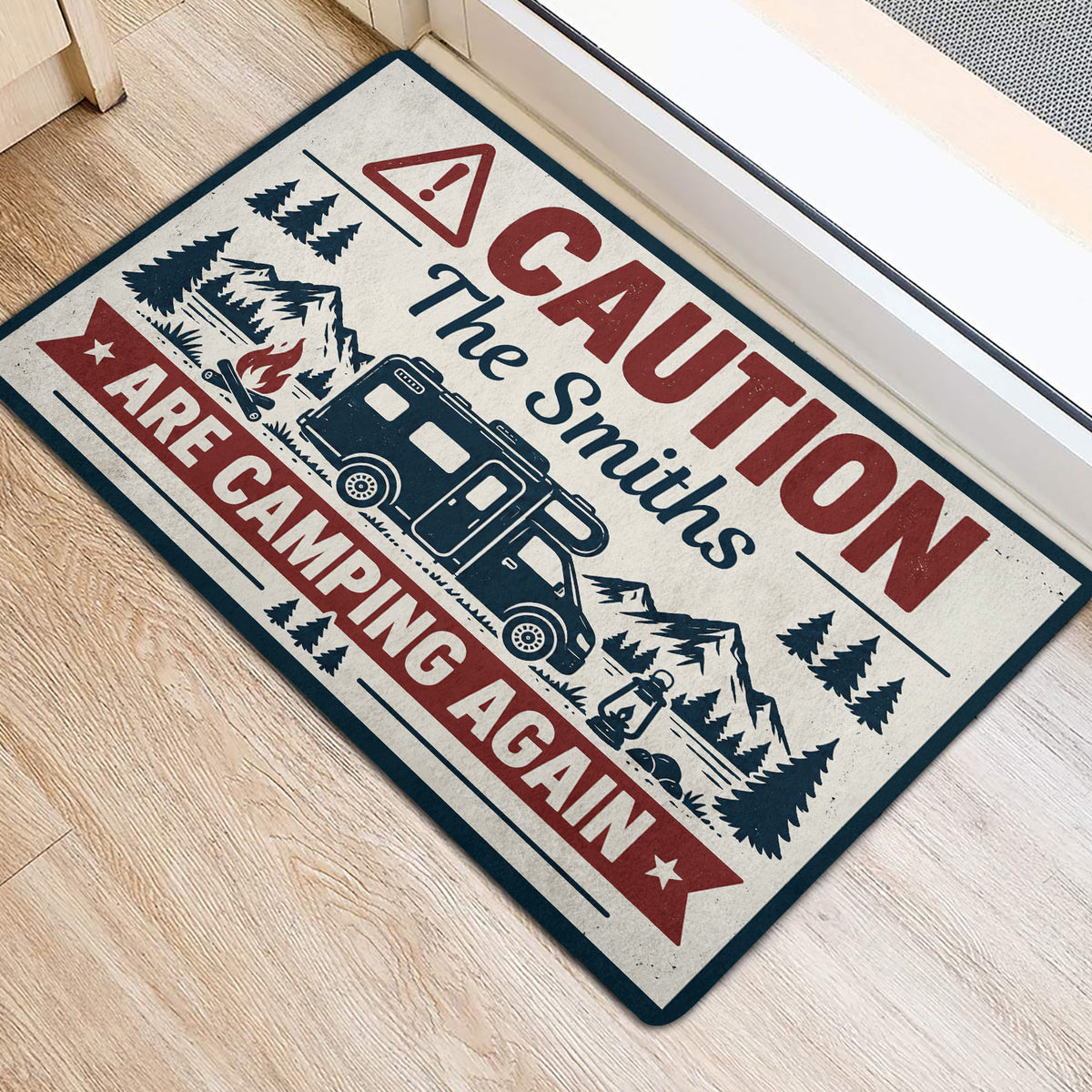 Angled view of a camping entryway mat featuring an RV, mountains, pine trees and rustic outdoor artwork