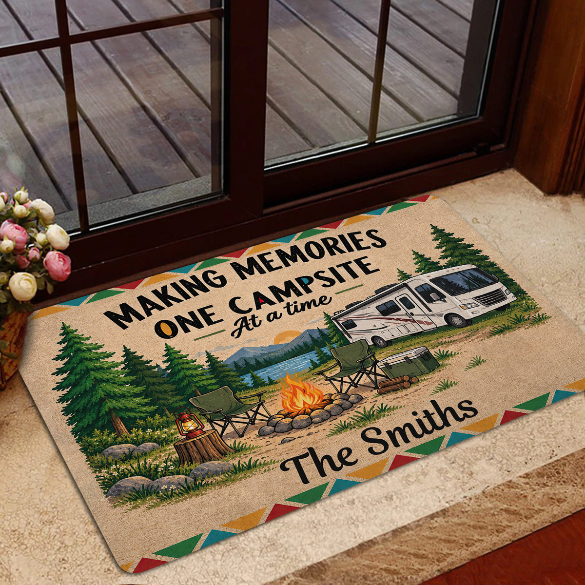 Campsite-themed door mat displayed near a glass entry door with an RV, campfire, and forest landscape